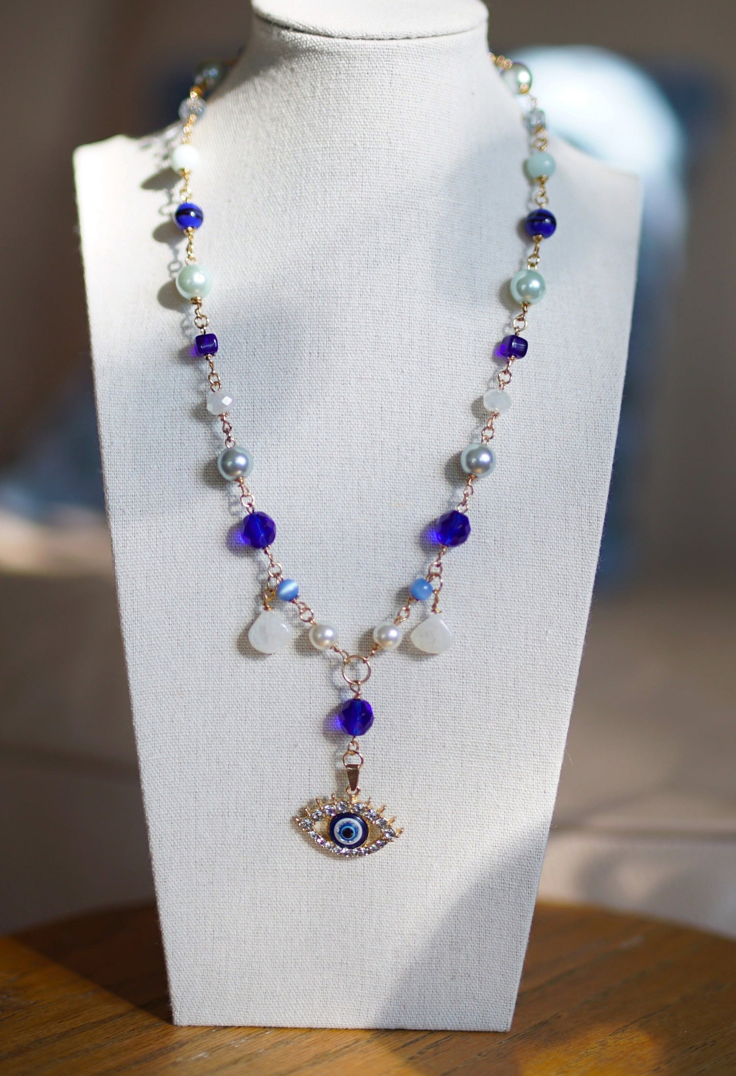 Necklace with an eye pendant on a white mannequin bust